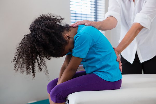 physiotherapist-giving-back-massage-to-girl-patien-EGAF94H.jpg