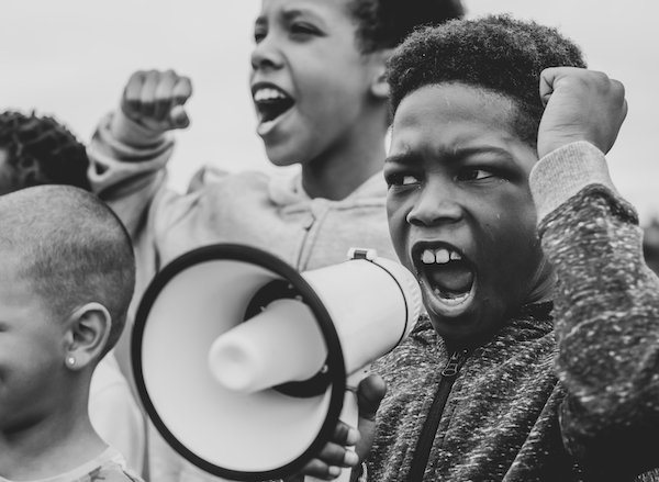 young-boy-shouting-on-a-megaphone-in-a-protest-L4ENM9F.jpg